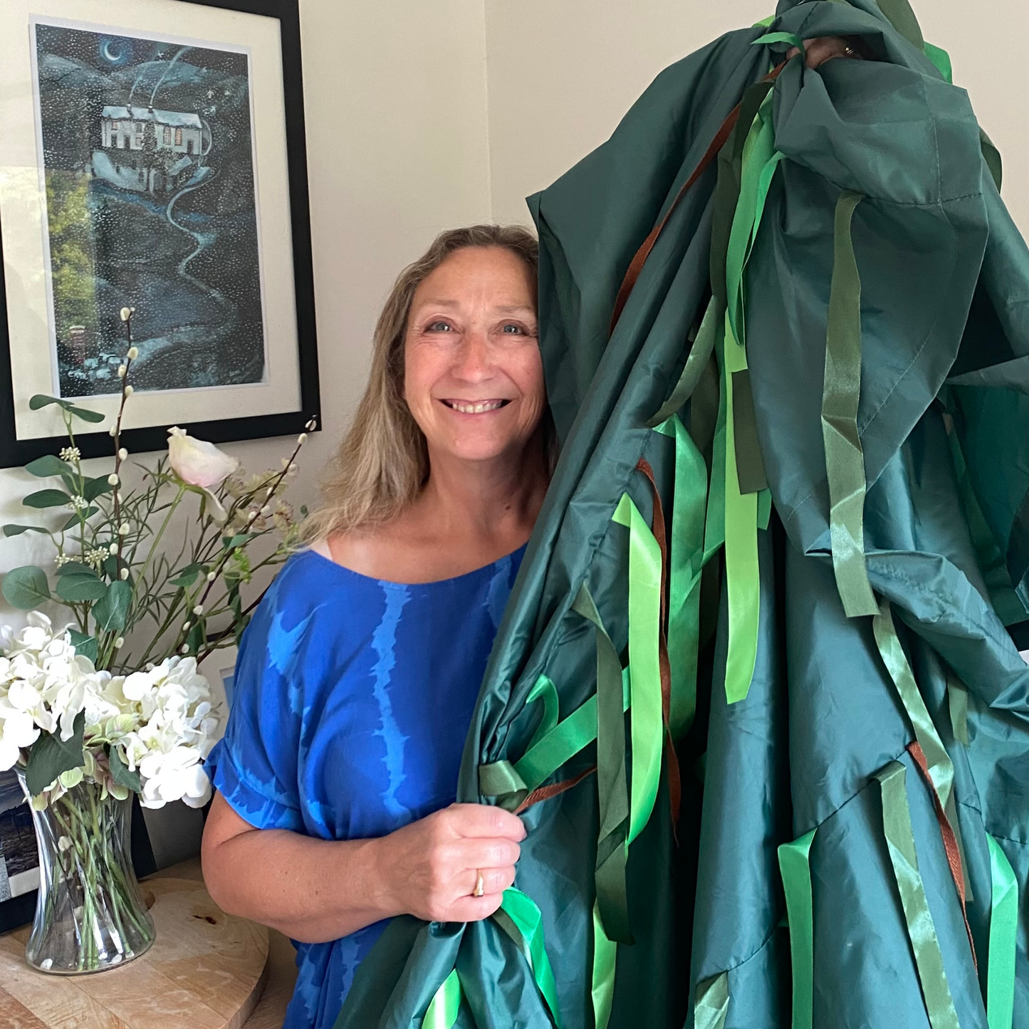 woman holding Jungle green Sensory Parachute up high and smiling