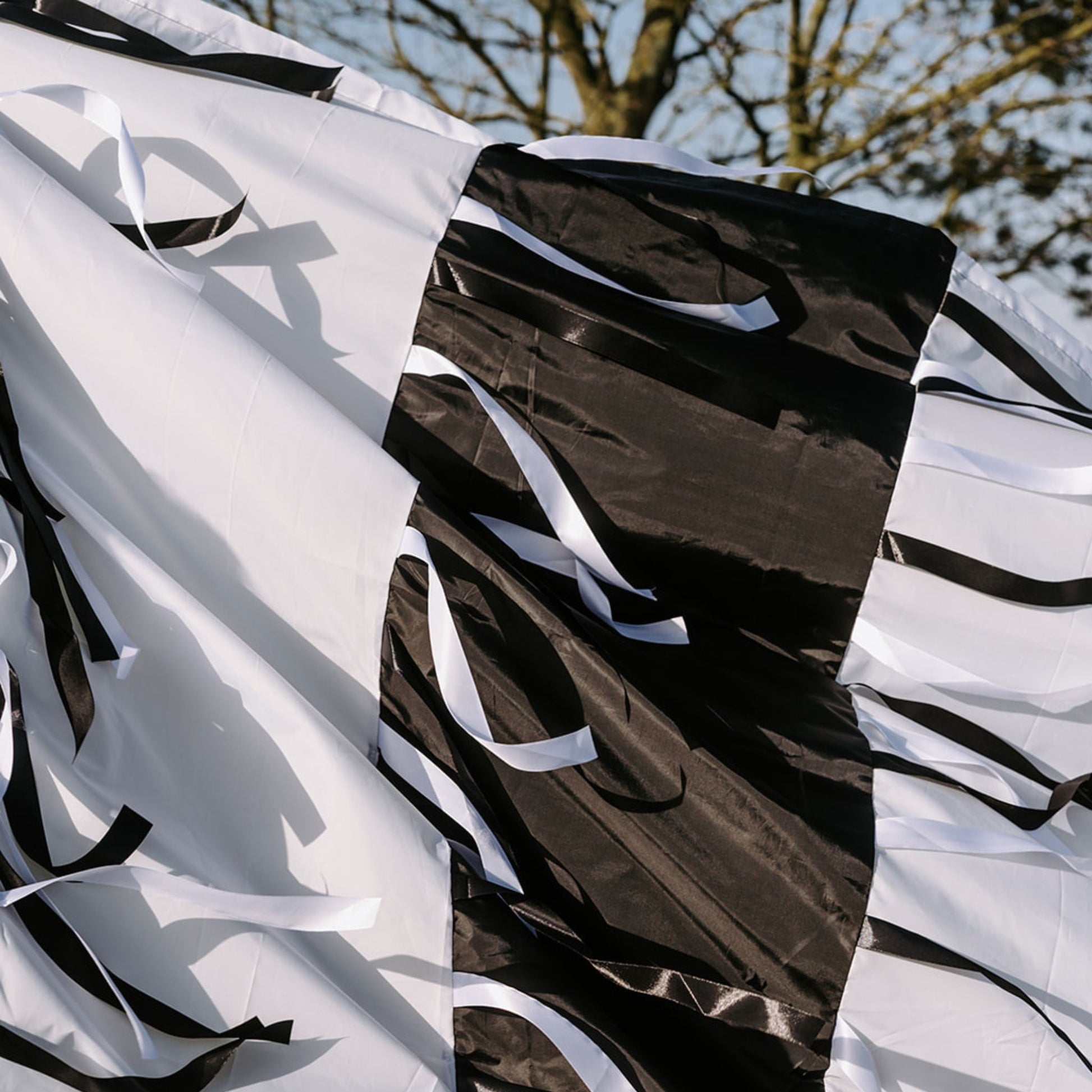 Close-up of the black and white sensory parachute fabric and flowing ribbons designed for baby development classes