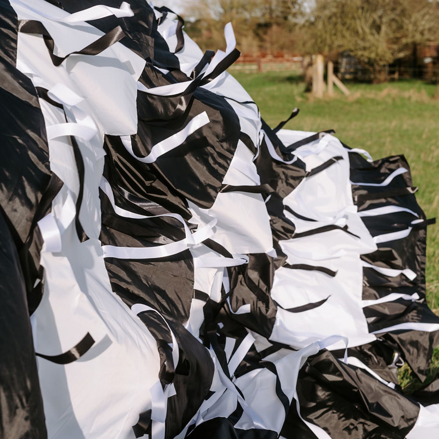 Folded sections of the black and white sensory parachute showing layers of ribbons used in professional baby classes