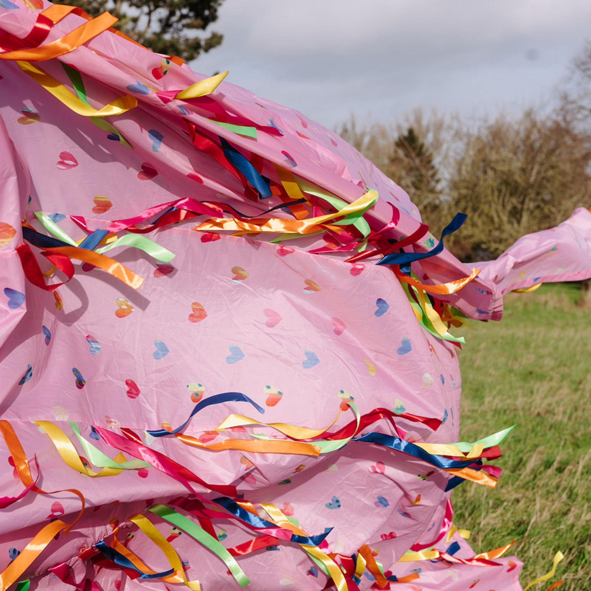 Colourful ribbons and heart-print fabric on the Love is in the Air Sensory Parachute designed for baby and toddler classes.