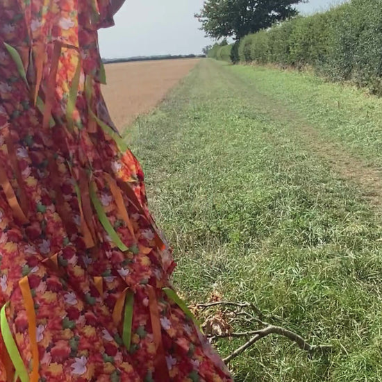 Person holding Autumn Sensory Parachute walking up and down a field as the ribbons move in the breeze