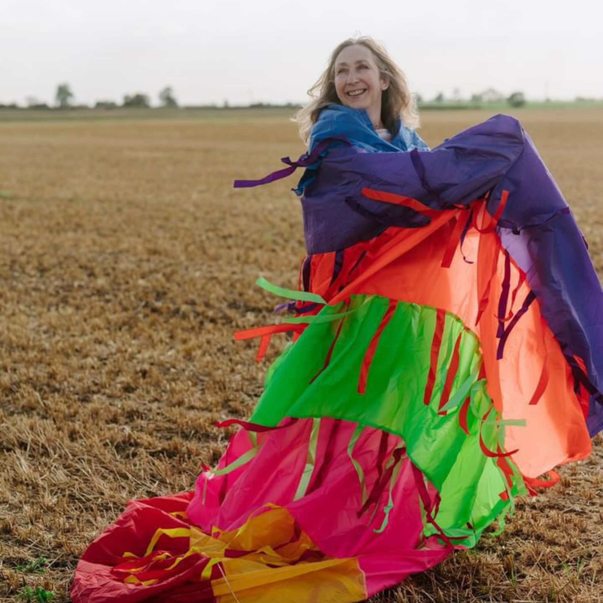 Rainbow sensory parachute being moved through the air, showing vivid colours used in sensory play sessions.