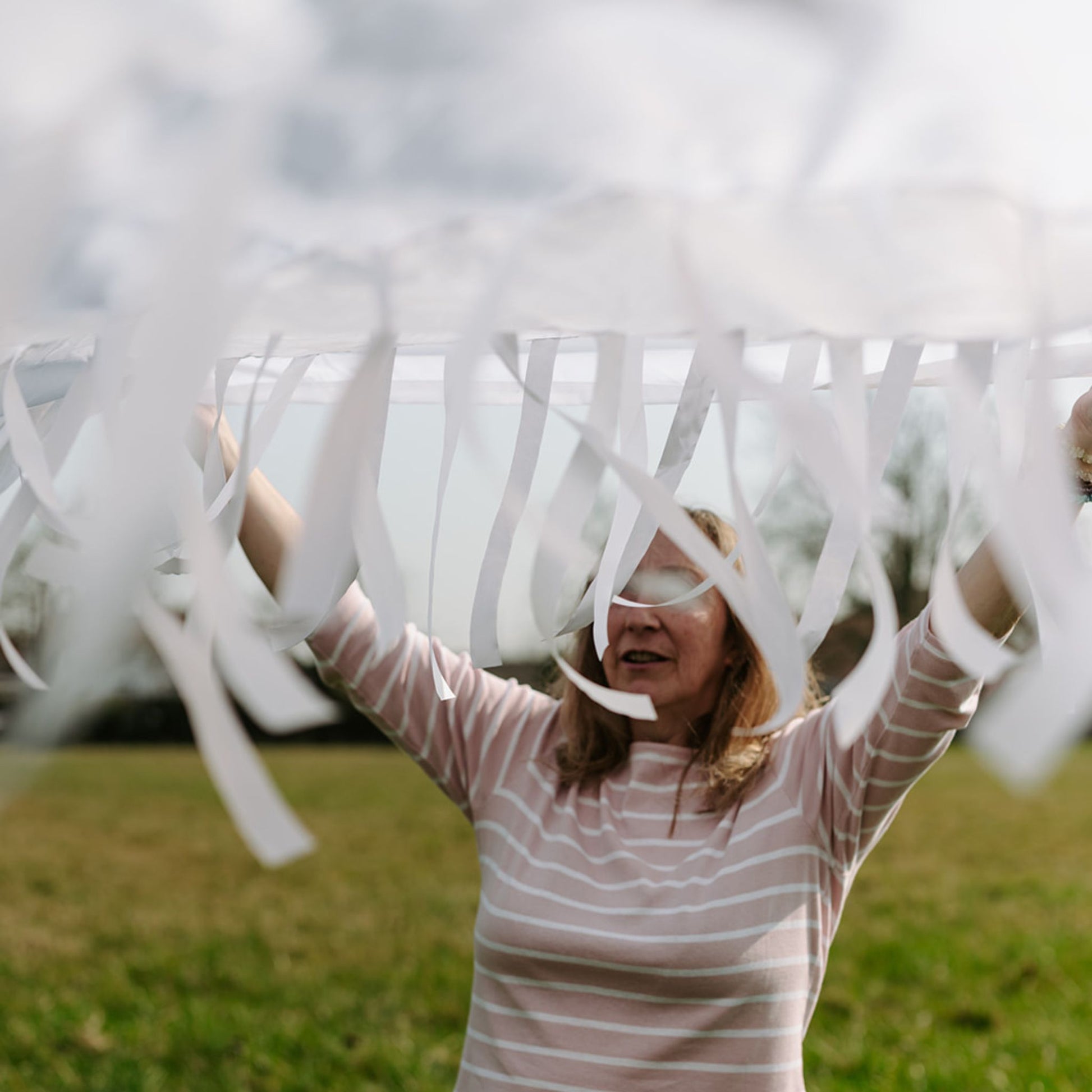 Snowfall sensory parachute held outdoors, showing flowing ribbons and soft textures designed for baby development classes