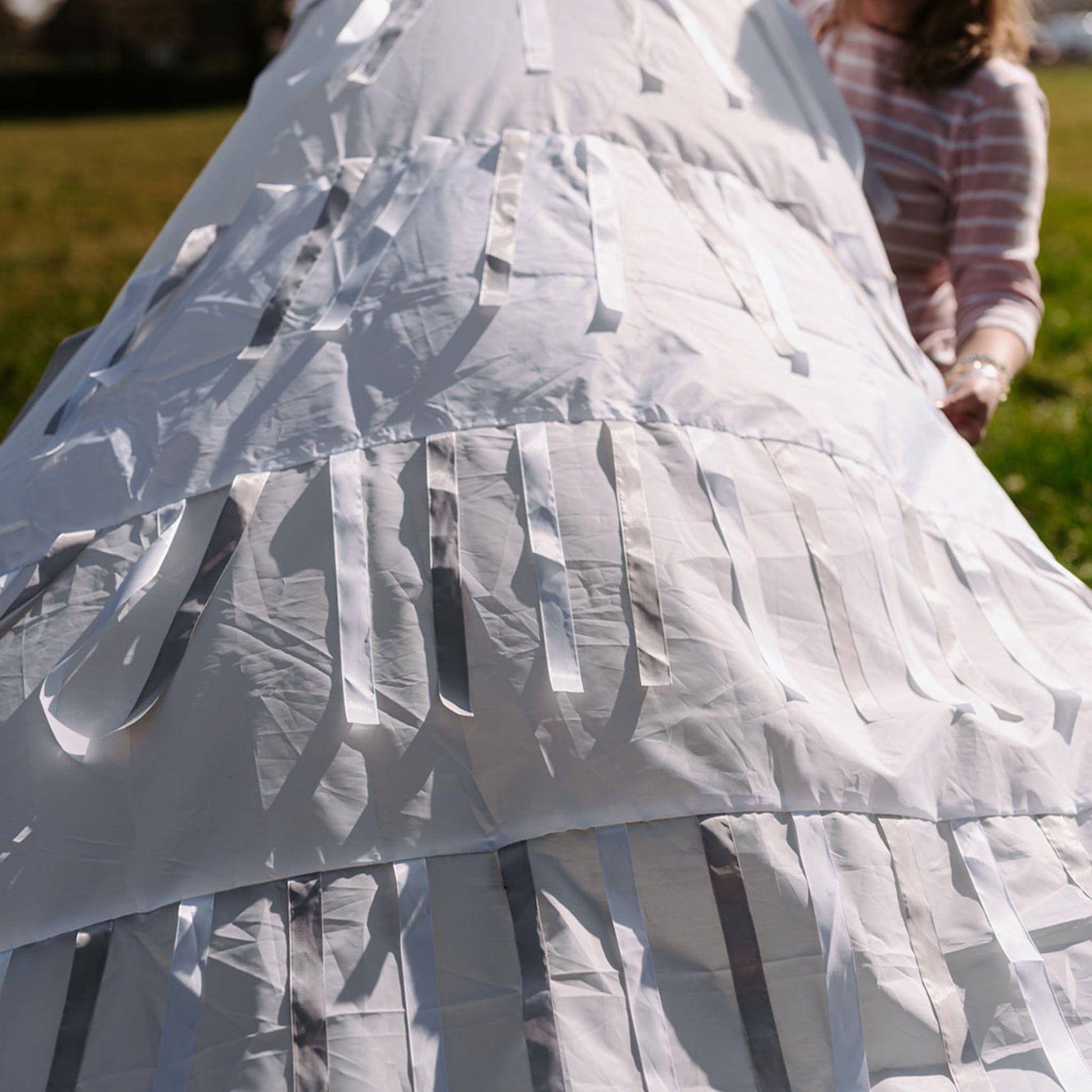 Layers of white fabric and ribbons from the Snowfall sensory parachute designed for sensory baby development sessions